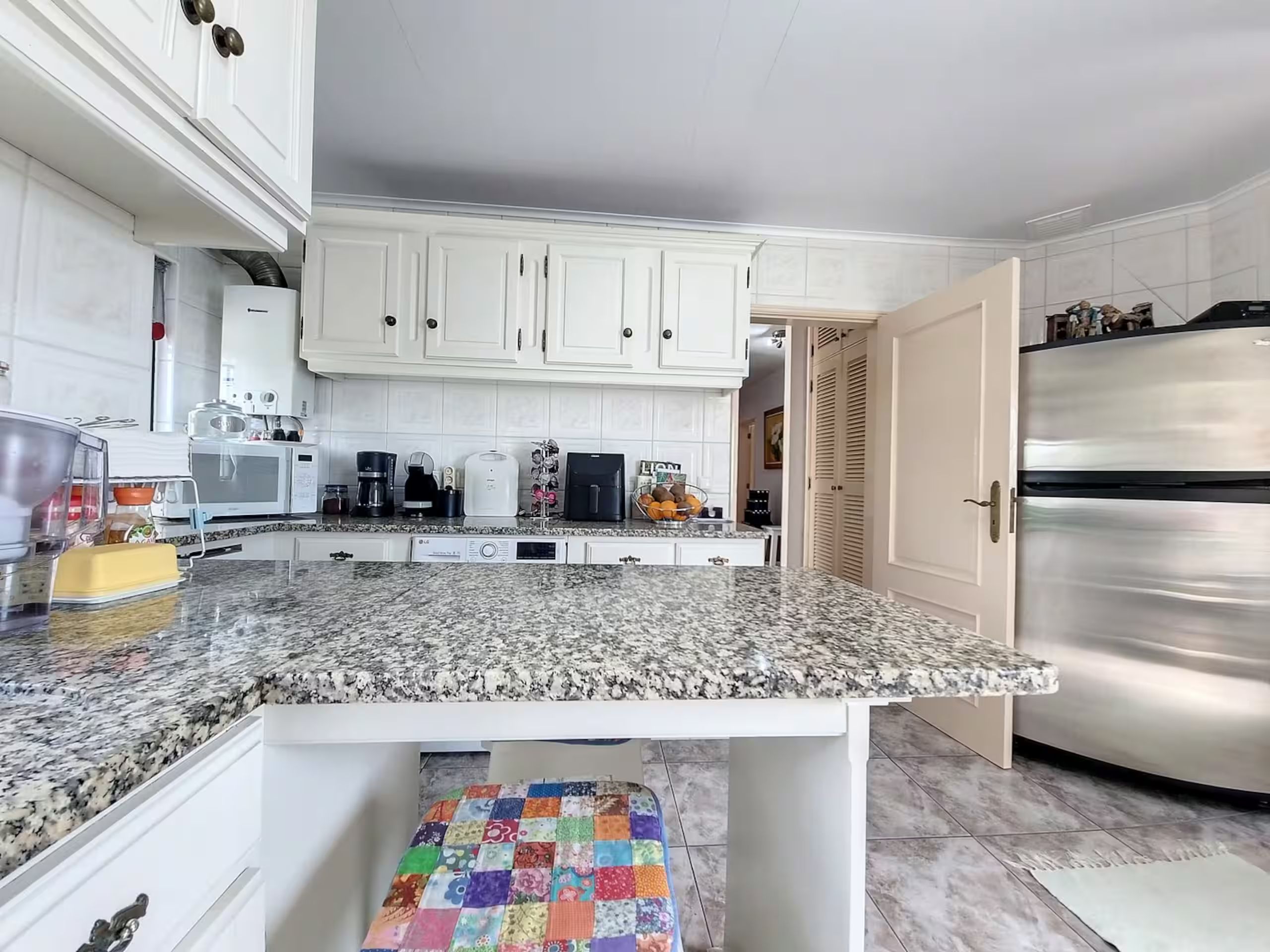 The kitchen from the breakfast counter, with the granite worktops and full appliances