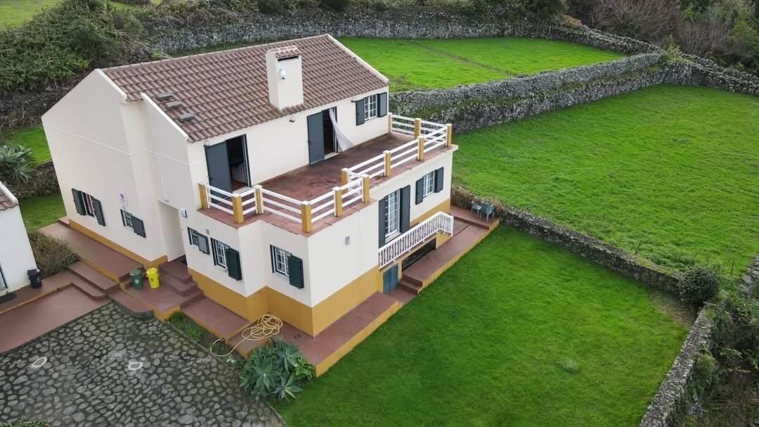 The house from above, with the walled lawn and the cobbled parking area around it